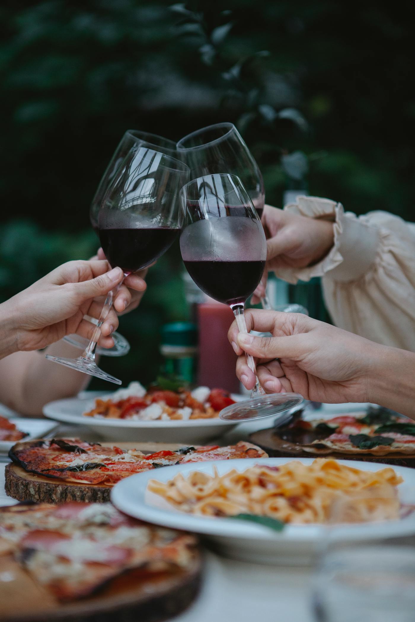 Friends sharing wood-fired pizza, pasta and Italian wine at The Warehouse Pizzeria, Preston